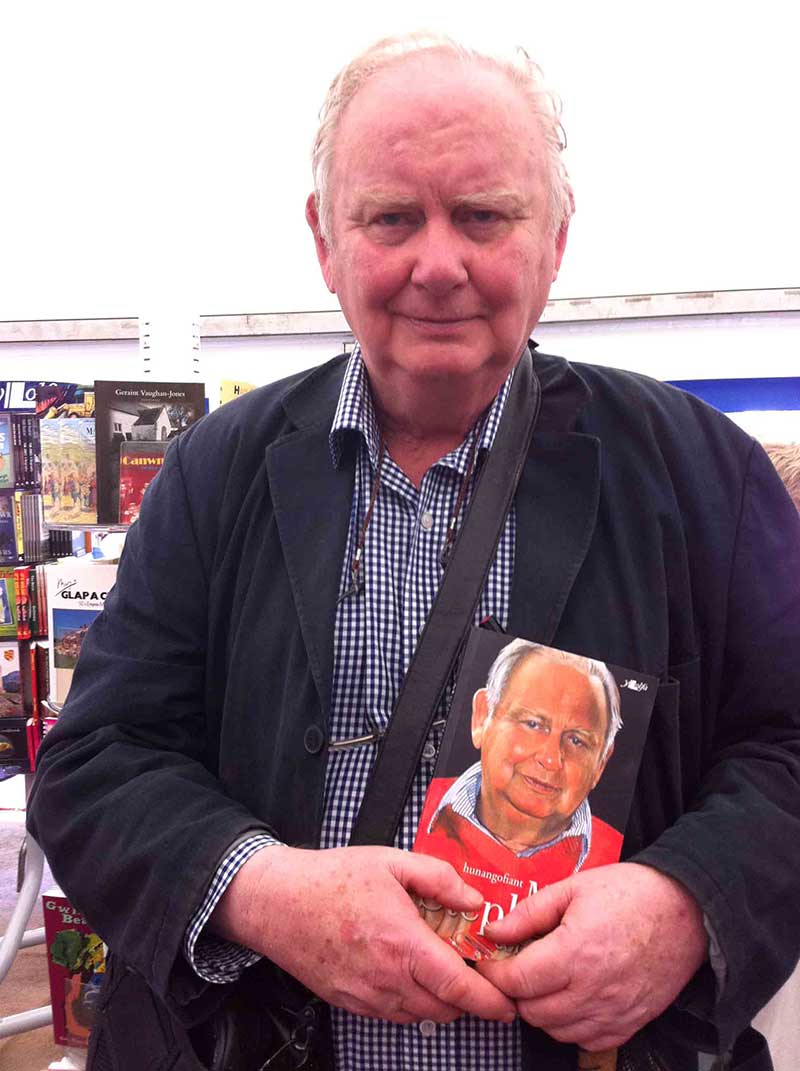 Photograph of Meic Stephens taken during the 2012 Eisteddfod. Meic is holding a copy of his Cofnodion, published by Y Lolfa. Image © Y Lolfa